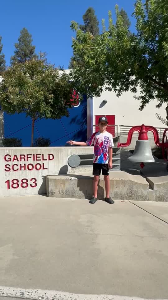 Grayson standing at the Garfield School 1883 bell